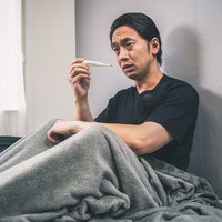 何度測っても平熱の男性～体温計で何度も確認する体調不良の写真