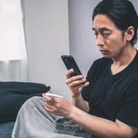 SNSにアップするため体温計を撮影する男性の写真