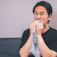 下着の強烈なにおいに顔が歪む男性の嫌悪表情の写真