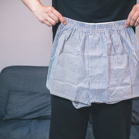 グレーのトランクスのサイズを確認する男性の写真