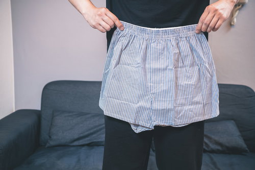 グレーのトランクスのサイズを確認する男性