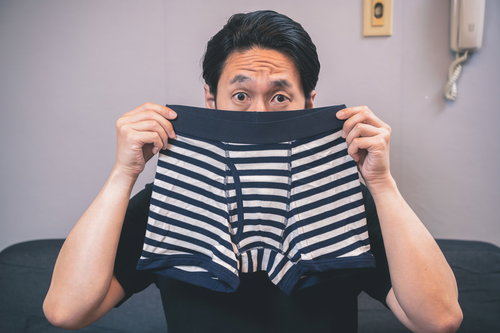 黒白ボーダー柄のボクサーブリーフのにおいを嗅ぐ男性