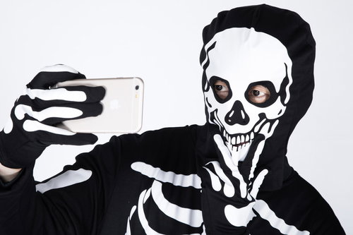 肉がないのに小顔効果を狙ってあご下ピースで自撮りをするガイコツ