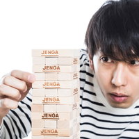 ひとりジェンガに興じる男性の写真