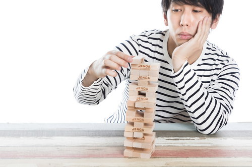 寂しく一人でジェンガで時間つぶしをする男性