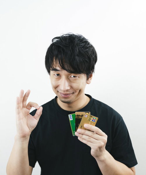 クレジットカードの種類はどれでもOK、右手でOKサインを出す男性