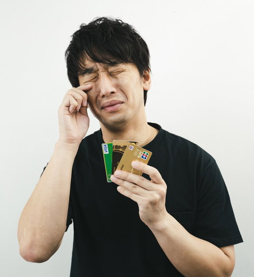クレジットカードを持ちながら涙を流すクレカ男子