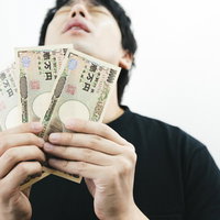臨時収入に歓喜する低所得の男性の写真