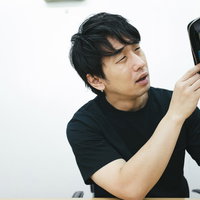 お財布の中身がない・・・空の財布を確認する男性の写真