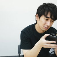 空の財布を手に持って現金がなくて途方に暮れる男性の写真