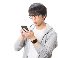 アニ文字で遊ぶ眼鏡の男性がスマートフォンを操作の写真