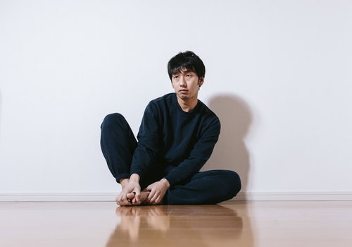 2時10分でとまったままの時計を見つめるニート男性