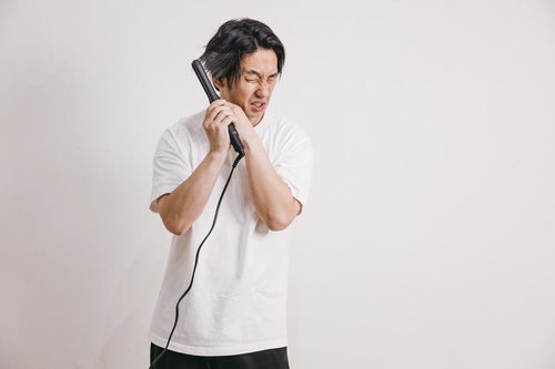 ヘアアイロンで火傷して痛がる男子生徒の顔