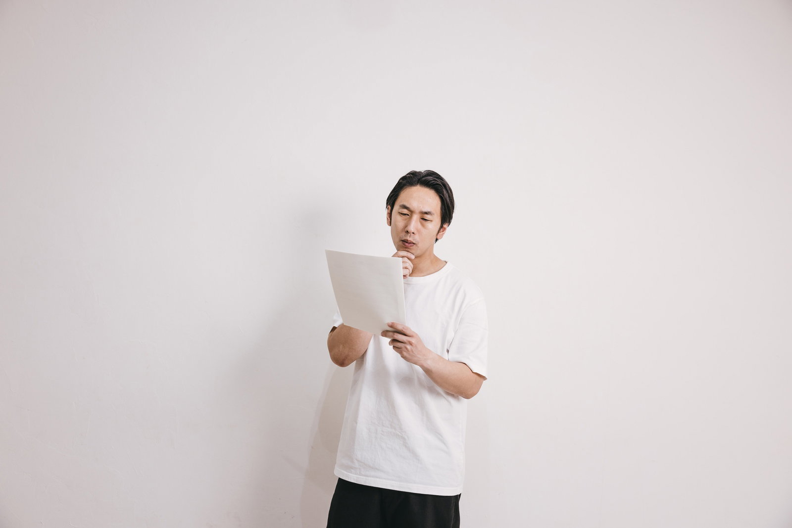 書類を読みながら考える男性［モデル：大川竜弥］