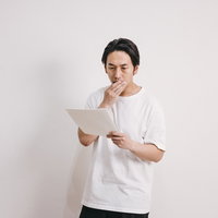 健康診断の結果に要検査があって驚く男性の表情と診断結果の写真