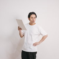 再検査結果に憤る男性（室内・立ち姿）の写真