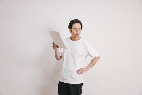 再検査結果に憤る男性（室内・立ち姿）