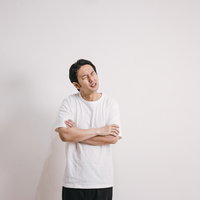 悪寒を感じて腕組みする男性の写真
