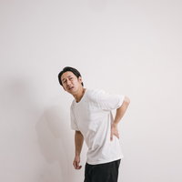 腰痛めてアイタタタ、背骨とぎっくり腰に苦しむ男性の写真