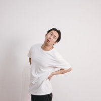 腰を押さえて痛みを訴えるぎっくり腰の男性の写真