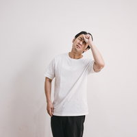 発熱で体調不良を感じ頭を押さえる男性の頭痛の写真