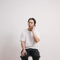 電話で言い訳を考える困った表情の男性のスマホ通話シーンの写真