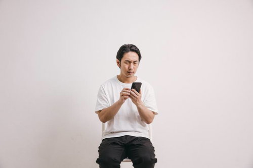 モバイル対応していないサイトの操作に四苦八苦する男性