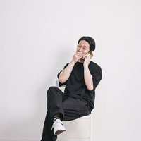 悪巧みの電話中、ニヤニヤと薄ら笑いを浮かべる男性の写真