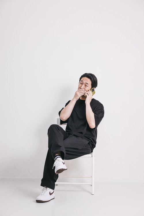 悪巧みの電話中、ニヤニヤと薄ら笑いを浮かべる男性