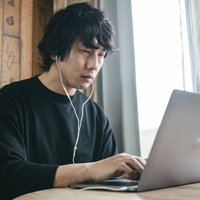 在宅勤務になってもバリバリ働く社員、ノートパソコンに集中の写真