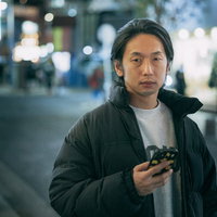 （あれ、この人どこかでみたことがある・・・）繁華街でスマートフォンを見る男性の写真