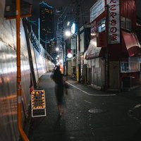 夜の新宿区百人町１丁目付近の路地裏、飲食店の看板が並ぶ繁華街の写真