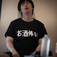 お酒怖い...と書かれたTシャツを着て椅子で寝落ちする男性の写真