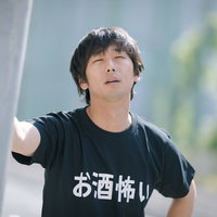 早朝の繁華街でたたずむ疲れた男性、過労と寝不足で体調不良の写真