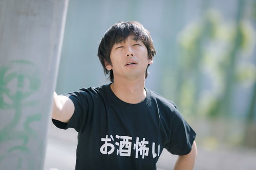 早朝の繁華街でたたずむ疲れた男性、過労と寝不足で体調不良