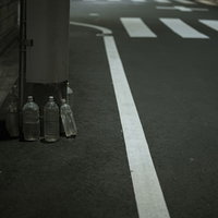 電柱の根元に用意された猫除けのペットボトルの写真