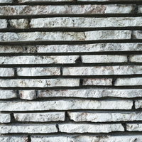 細長に切れ目が入ったグレーの石のタイルの写真