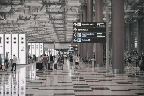 シンガポール空港の搭乗前、案内板を見て移動する人々