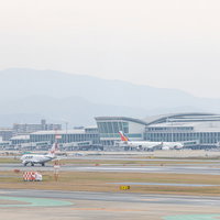福岡空港の滑走路に駐機する旅客機とターミナルビルの写真