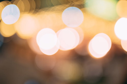 ボケたライトアップの温かみのある光が灯るイルミネーション背景