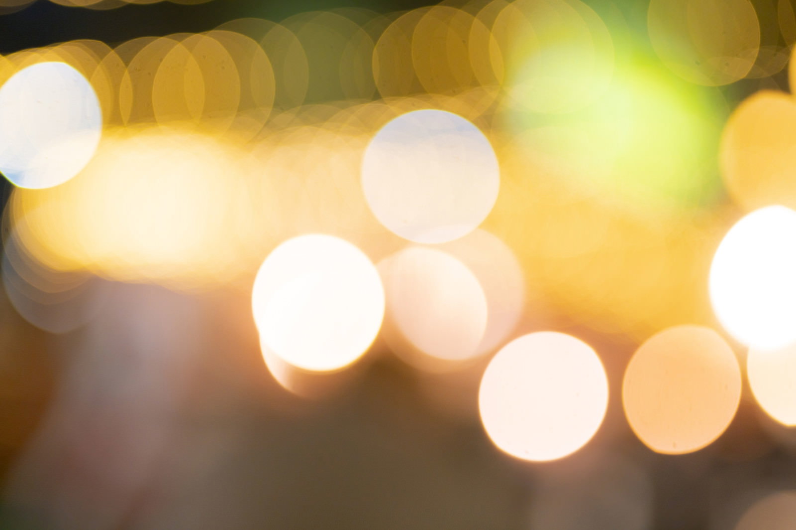 暖色の光源によって作られた丸いボケが散らばる光の表現