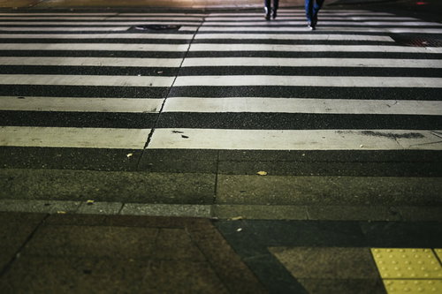 横断歩道を歩く足元、白と黒のゼブラ模様の歩行者