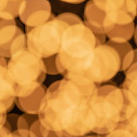 オレンジ色の玉ボケがライトアップで浮かぶ光景の写真