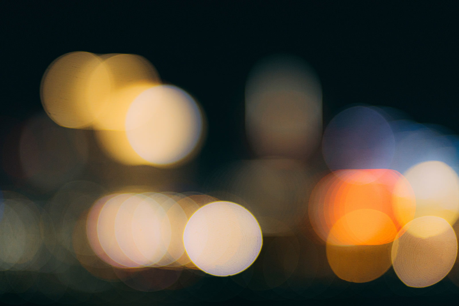 暗闇に暖色系の光が丸くボケて浮かんでいる玉ボケの様子