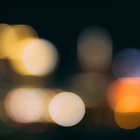 暗闇に浮かぶ暖色系の玉ボケとボケ味の写真