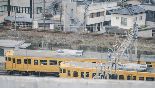 山陽本線を走るクハ115形電車、駅に停車する黄色い通勤電車