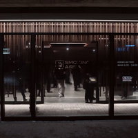 屋外の喫煙所でシルエットになる複数の人びとの写真