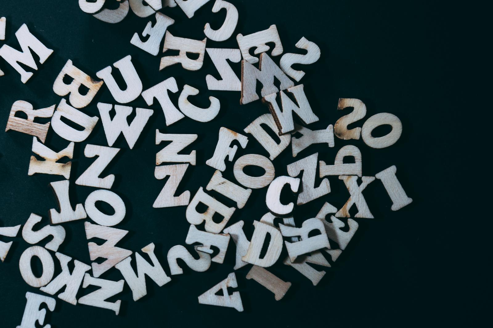 木製アルファベット文字ピースが散らばっている