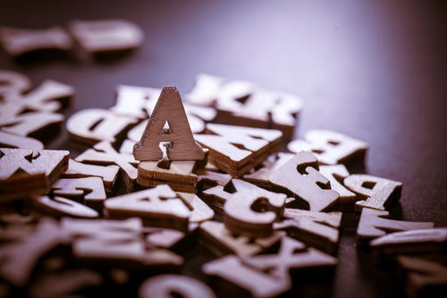 木製のアルファベット文字が散らばる中でAの文字が立つパスワード風景