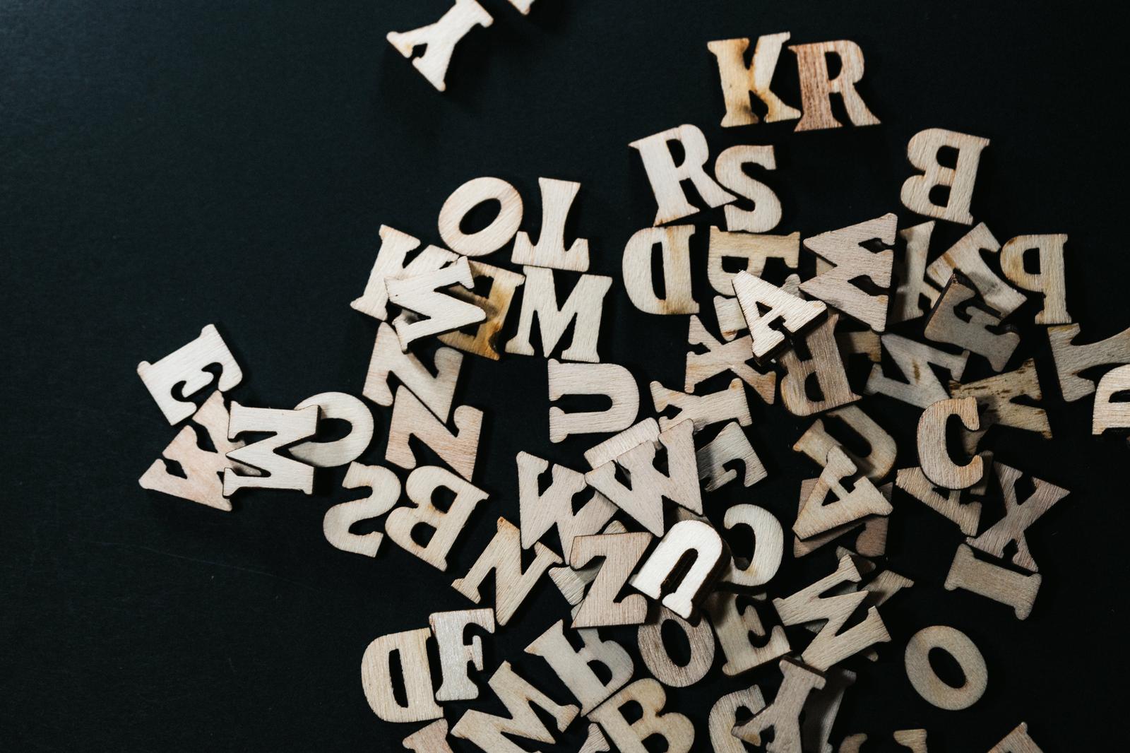 濃紺の背景に散乱する木製のアルファベット文字